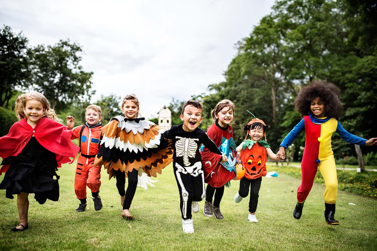 A group of children dressed in costumes running in a park, supported by a proposal for Federal Government funding through the GSA.