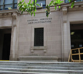 A Federal Government building with a tree in front of it.