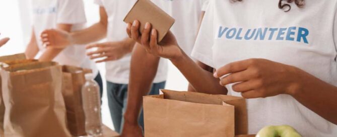 A group of volunteers holding bags of food who are providing support to a proposal for the Federal Government.