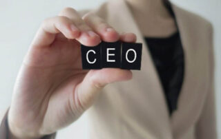 A woman holding up a block with the word ceo on it, demonstrating her success as a prominent figure in the business world. | Revolutionary Solutions A woman holding up a block with the word ceo on it, demonstrating her success as a prominent figure in the business world.